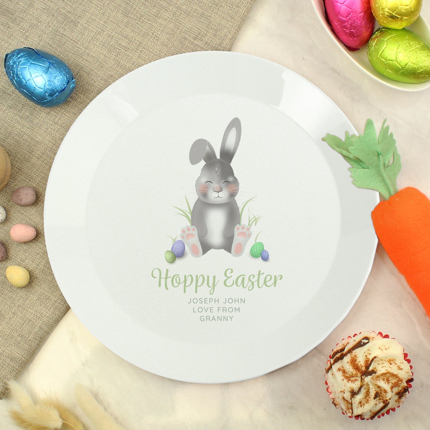 Easter-themed plate with a rabbit illustration and 'Happy Easter' text, surrounded by Easter decorations.