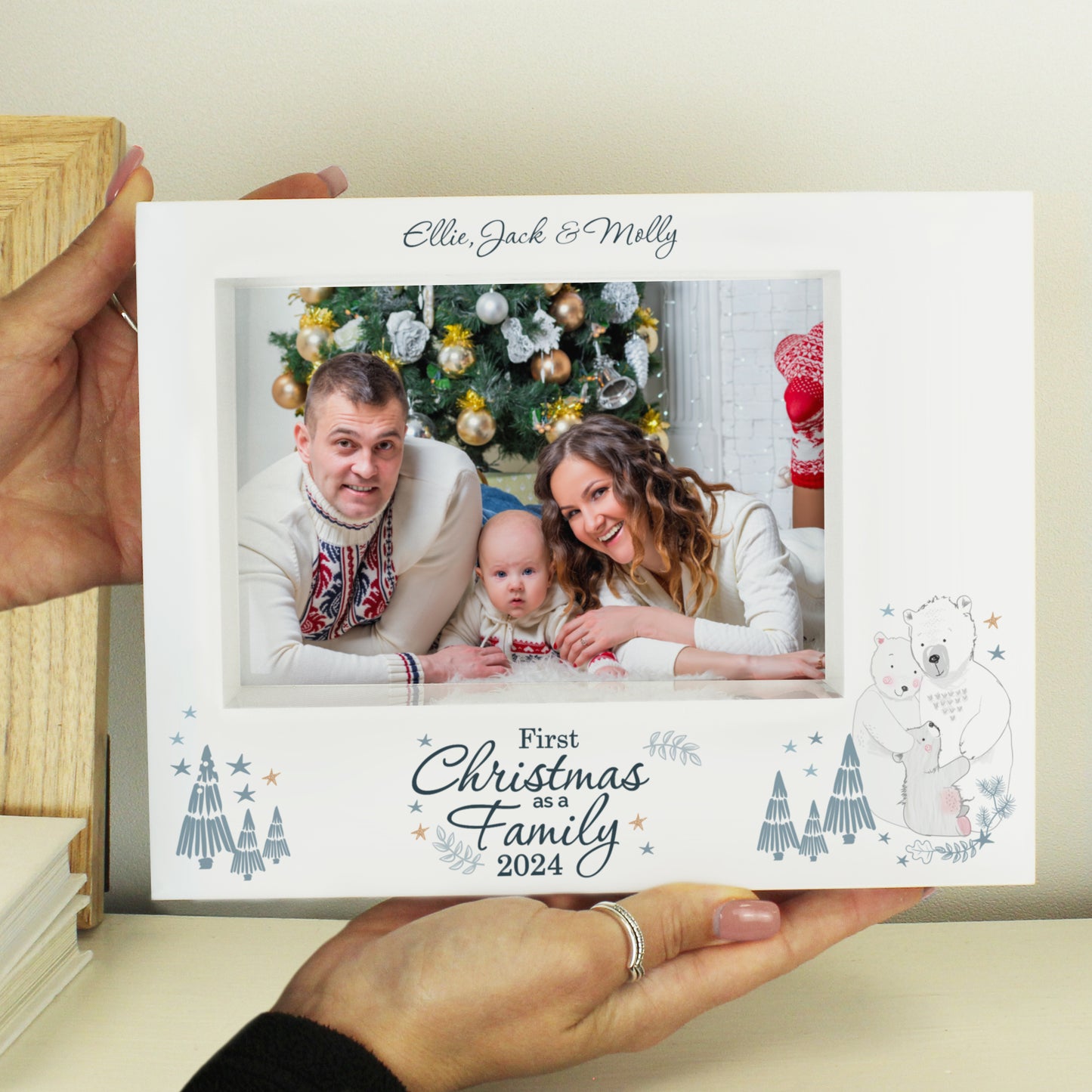 Card with a family photo and 'First Christmas as a Family 2024' text, held by a person.