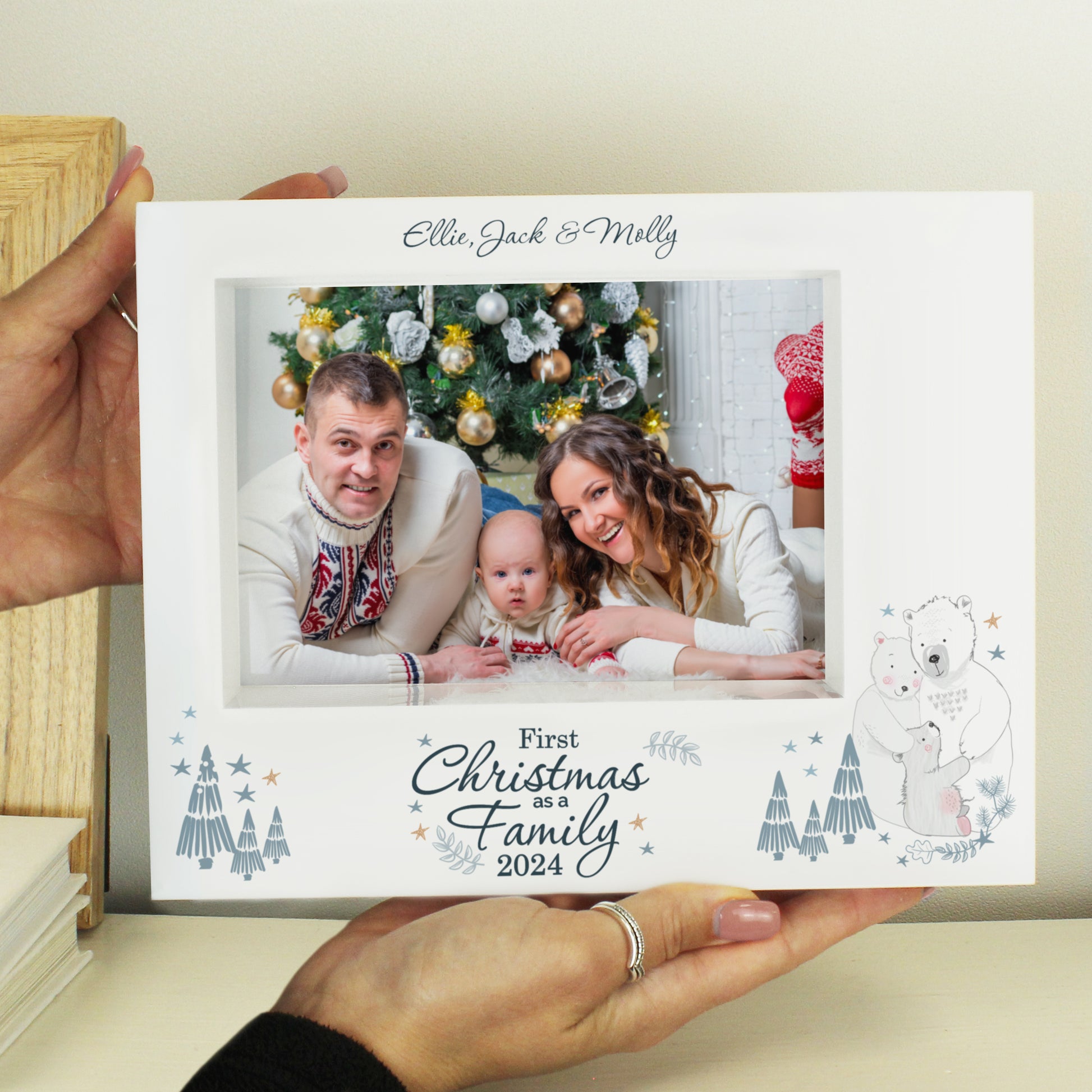 Card with a family photo and 'First Christmas as a Family 2024' text, held by a person.