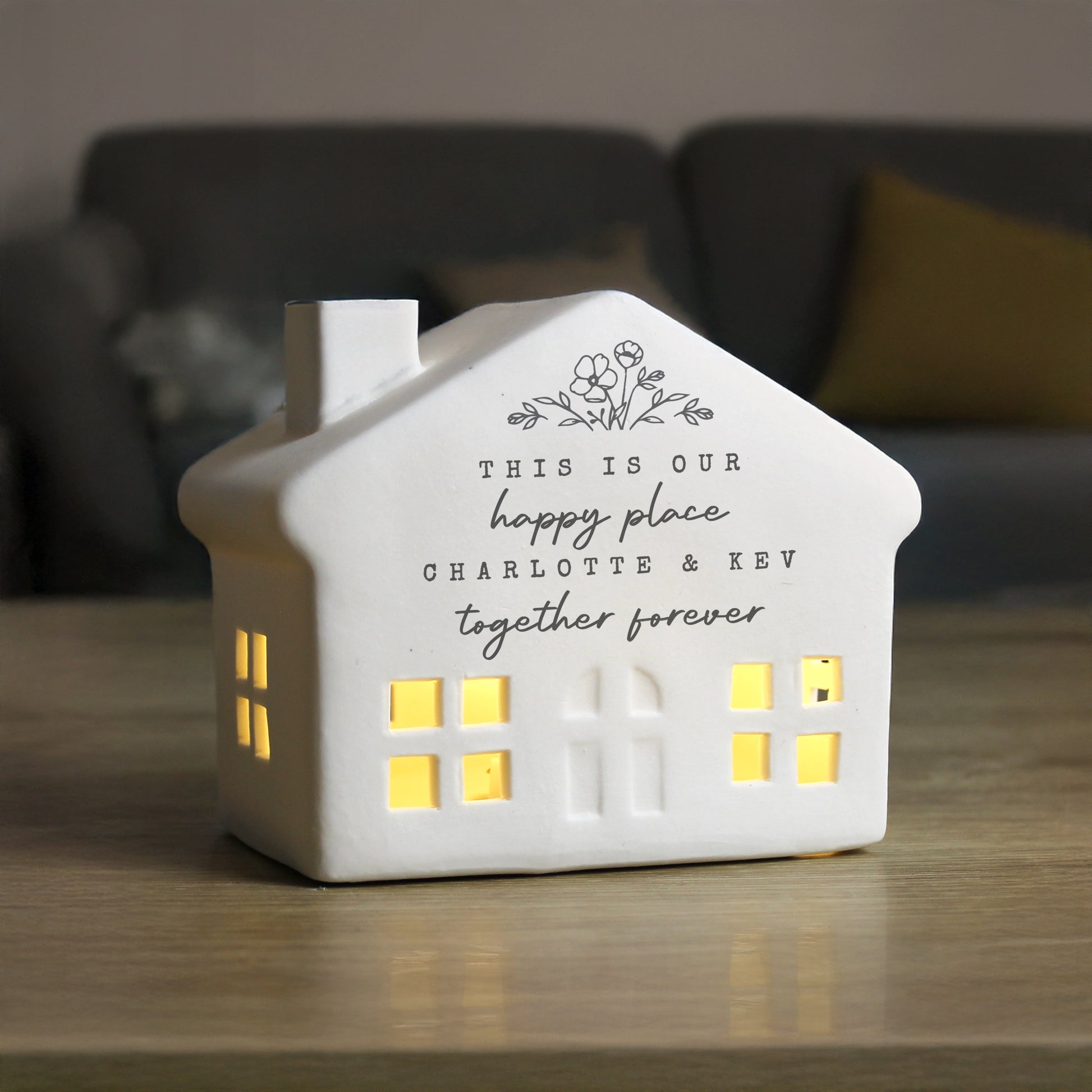 House-shaped night light with personalized text on a wooden surface
