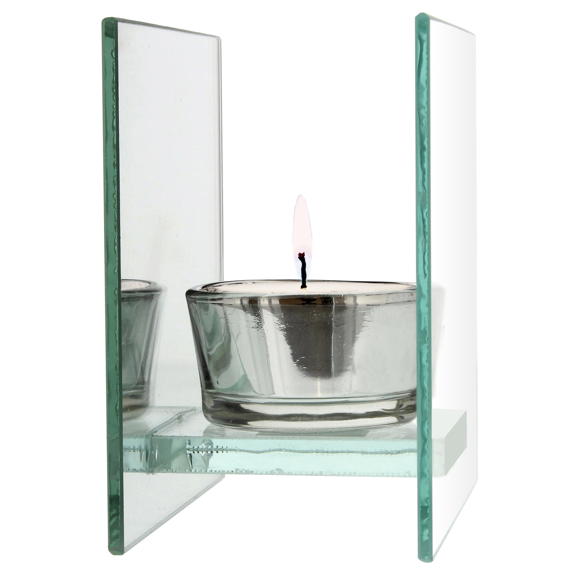 Glass candle holder with a lit candle on a white background