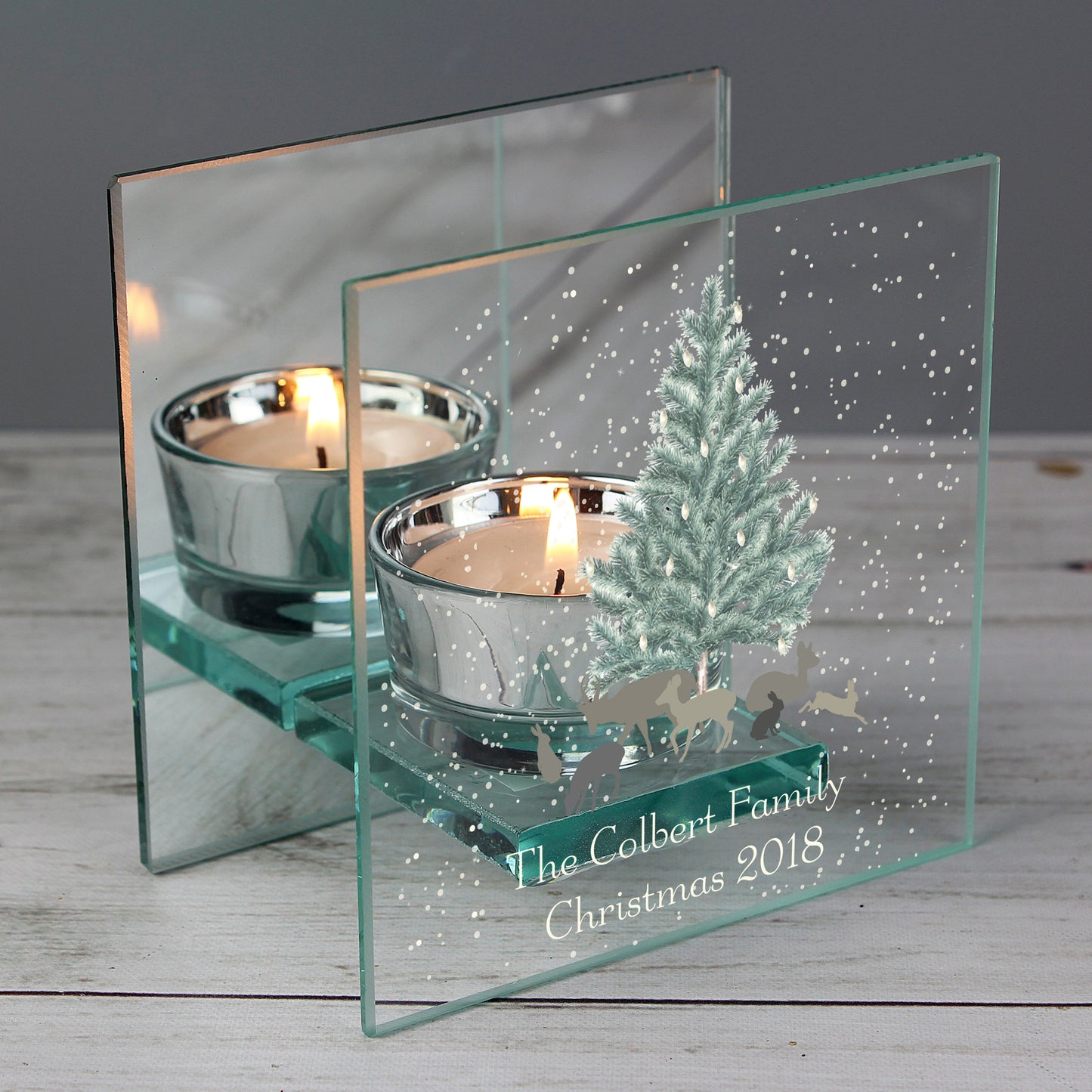 Personalised Glass candle holder with Christmas design and 'The Colbert Family Christmas 2018' text on a wooden surface.