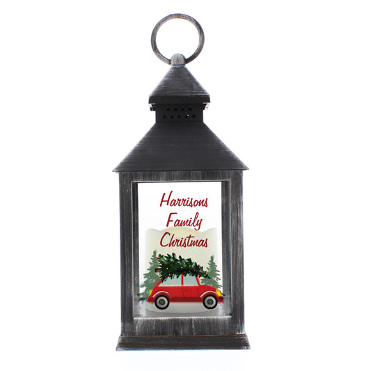 Decorative lantern with a Christmas design featuring a red car and tree, on a white background.