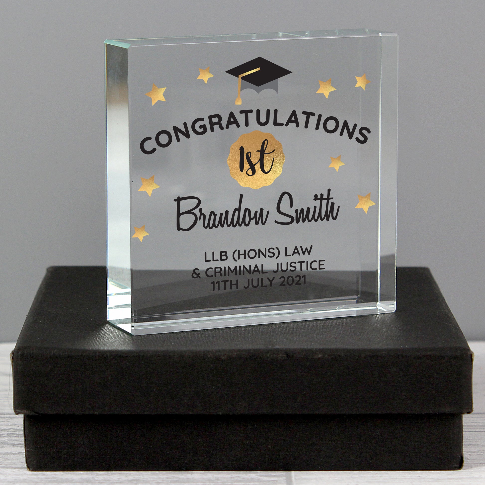 Glass graduation award with engraved text on a black box