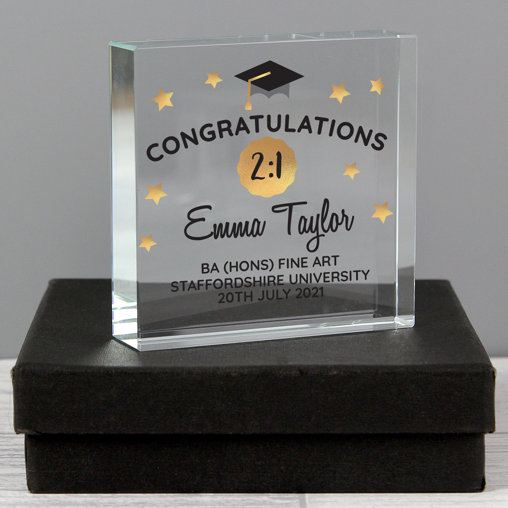 Graduation-themed glass award with engraved text on a black box.