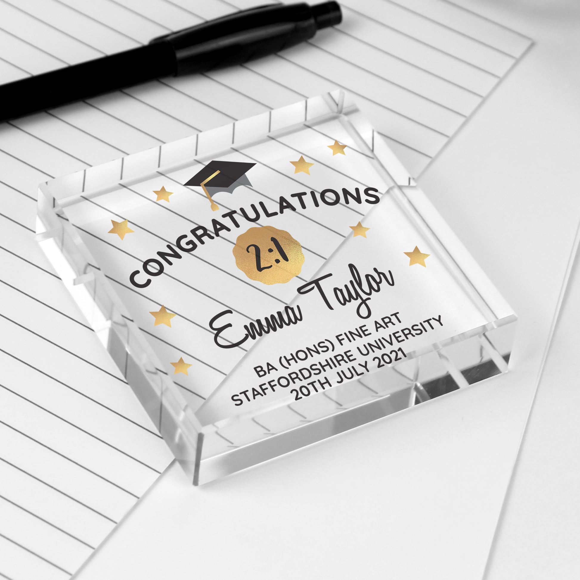 Graduation-themed decorative block with personalized text on a white surface