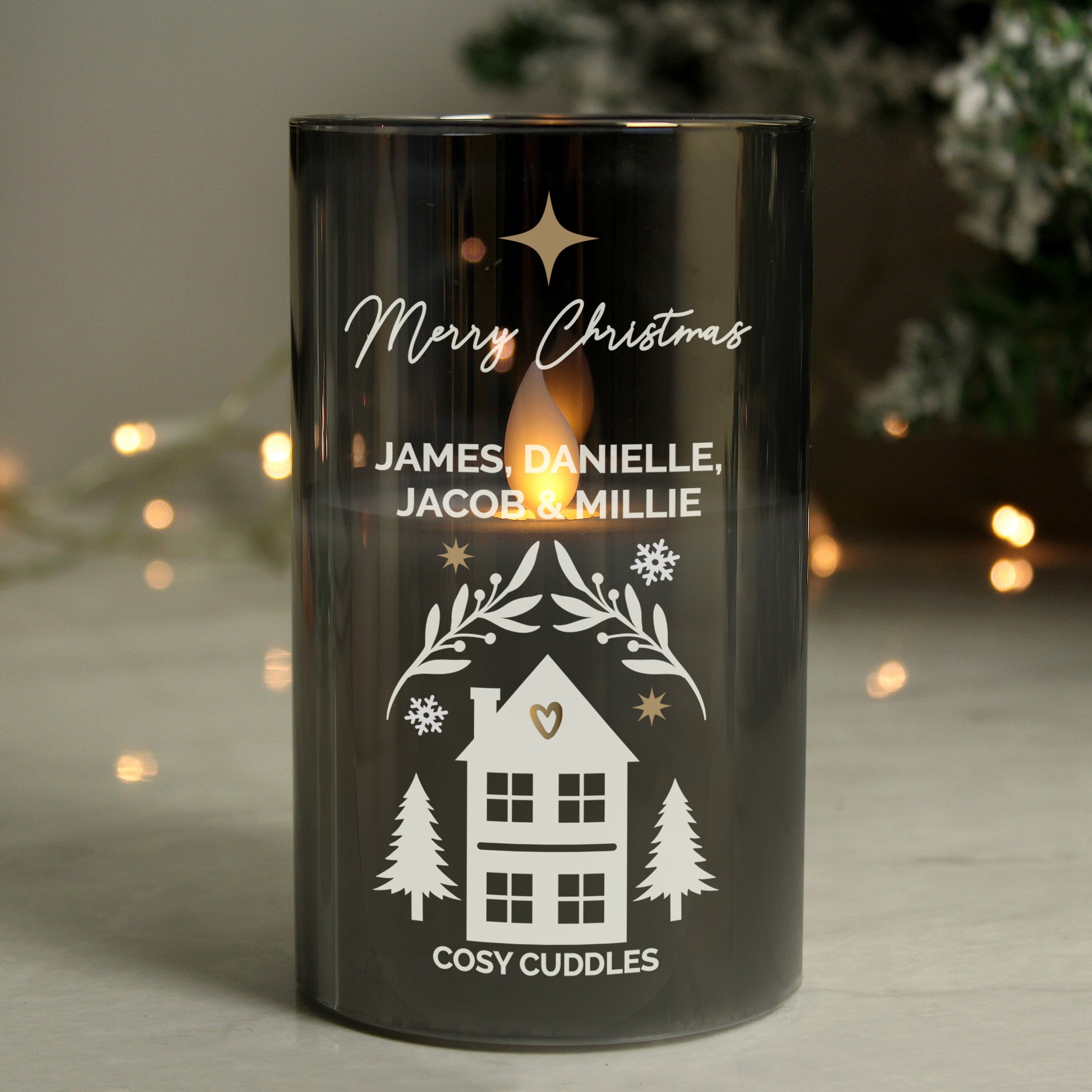 Black candle holder with personalised text and house illustration on a blurred background