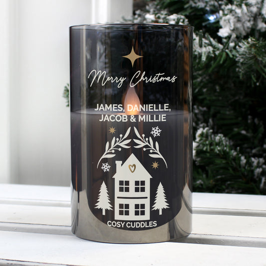 Decorative candle with personalised text on a windowsill with a snowy outdoor background