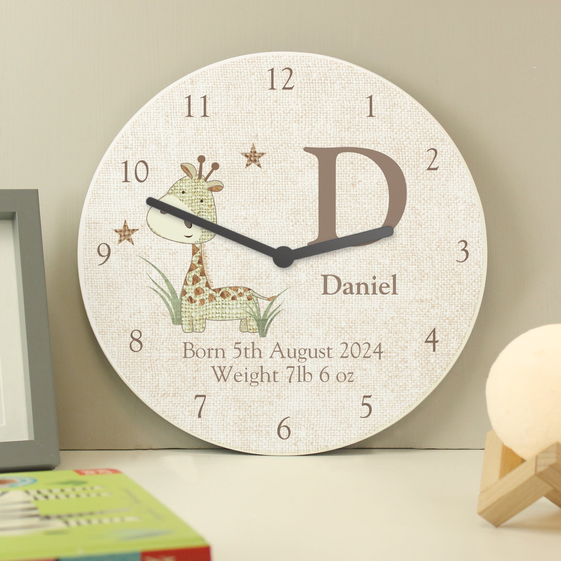 Wall clock with a giraffe design and personalised text on a neutral background