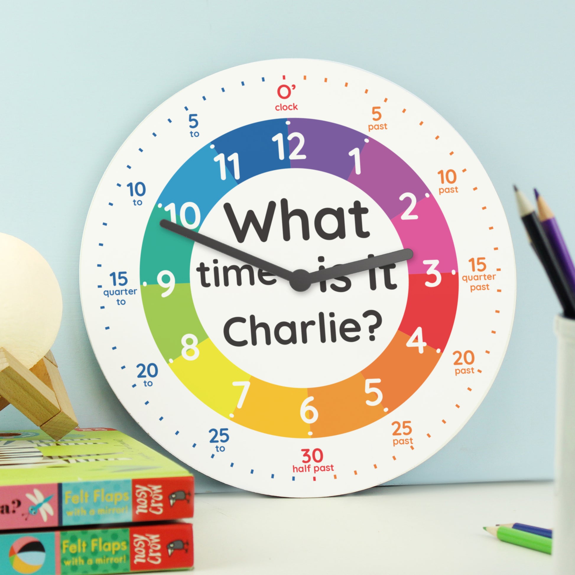 Colourful clock with 'What time is it Charlie?' text on a light blue background