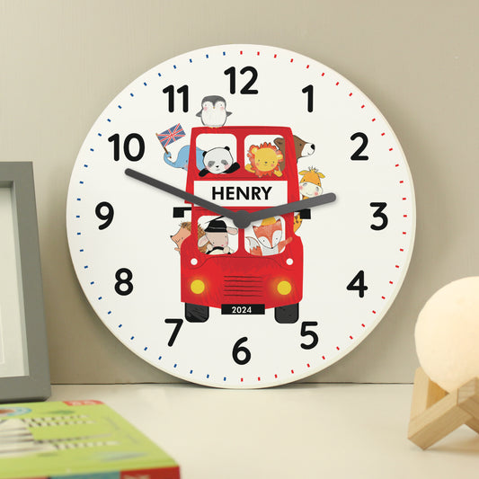 Personalised Children's wall clock with a red bus design and the name 'HENRY' on a beige wall.