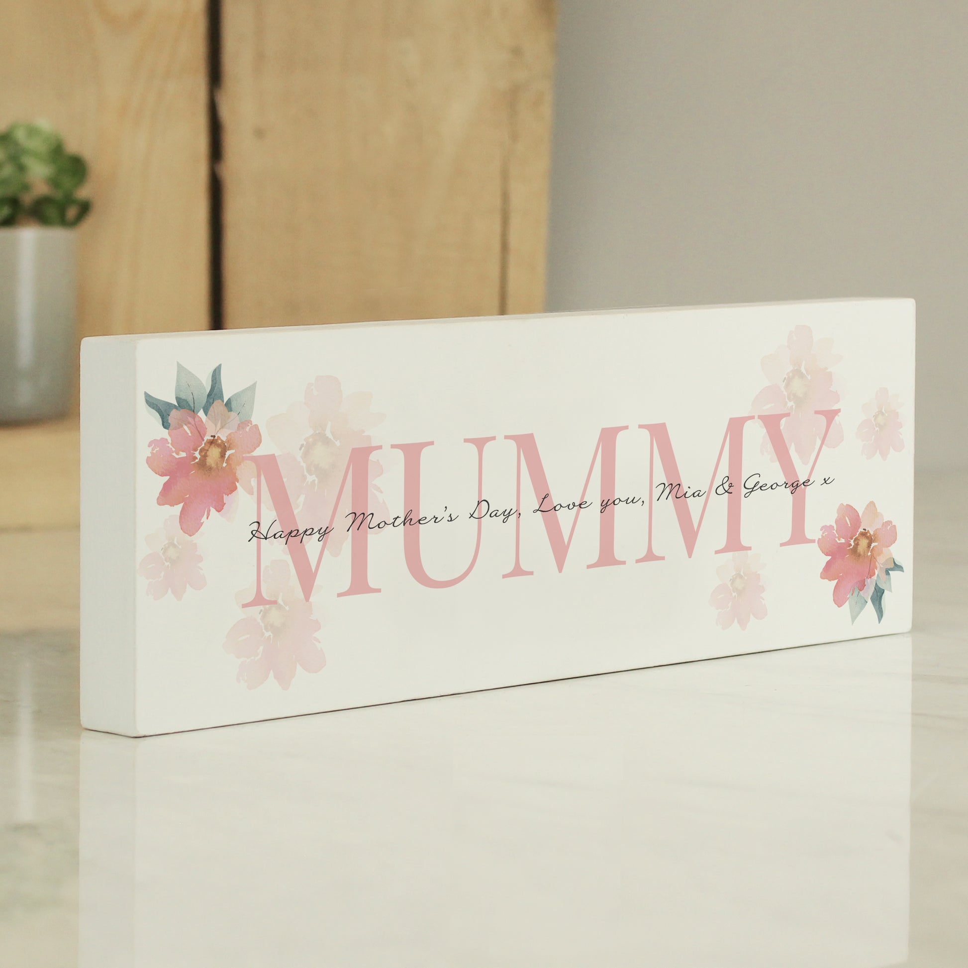 Decorative sign with 'MUMMY' and floral designs on a white background