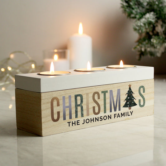 Wooden Christmas candle holder with three lit candles on a reflective surface.