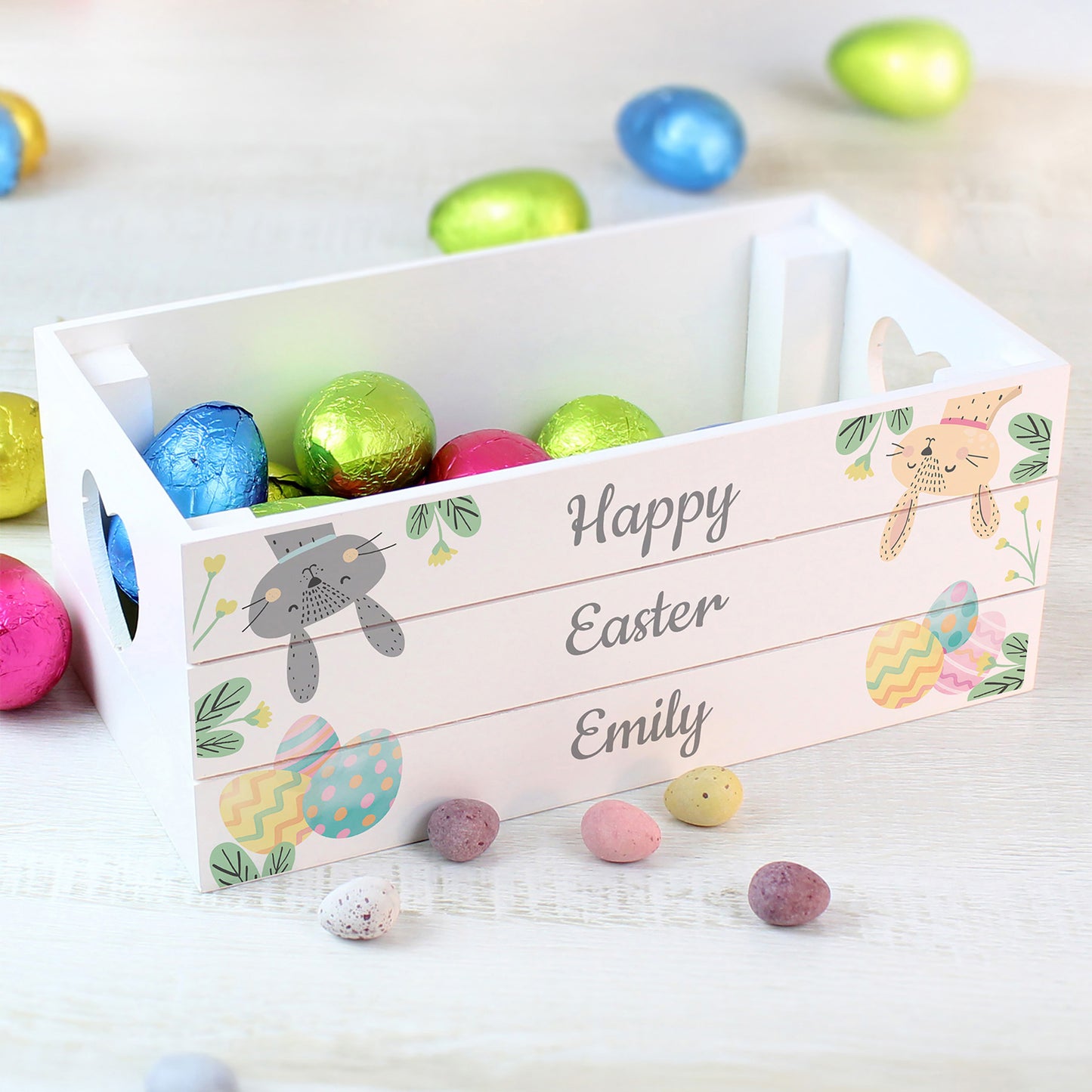 White Easter basket with colorful eggs and personalised text on a light background