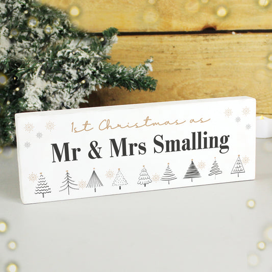 Personalised Christmas sign with tree designs and text in front of a decorated Christmas tree.