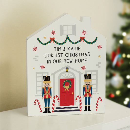 Personalised Decorative house-shaped card with Christmas-themed design and text, placed against a blurred festive background.