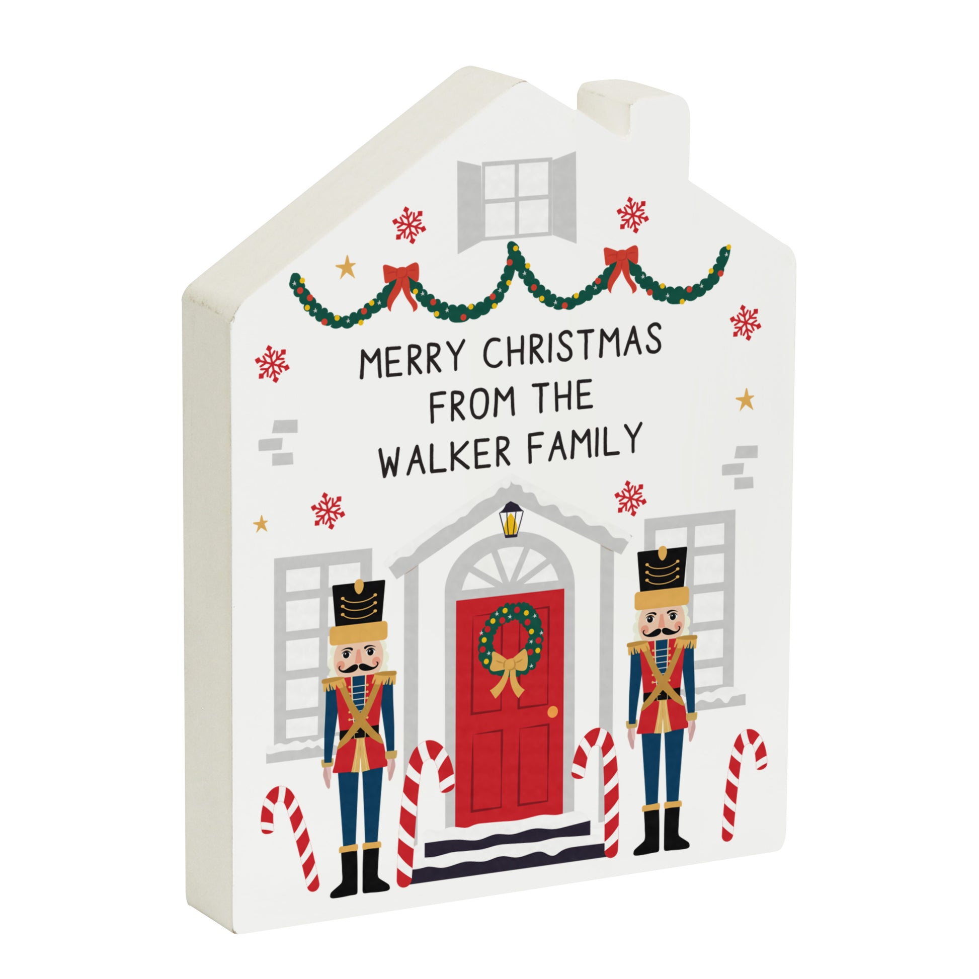 Decorative Christmas house-shaped sign with 'Merry Christmas from the Walker Family' text, nutcrackers, and candy canes on a white background.
