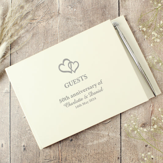 Personalised guest book for a 50th anniversary on a wooden surface with decorative elements.