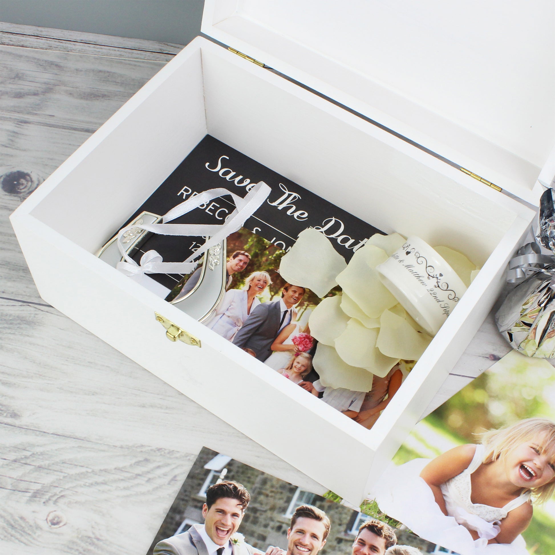 Wedding-themed items including a ring box and 'Save the Date' cards in a white box on a wooden surface.