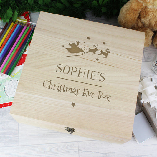 Wooden Christmas Eve box with engraved text on a festive background
