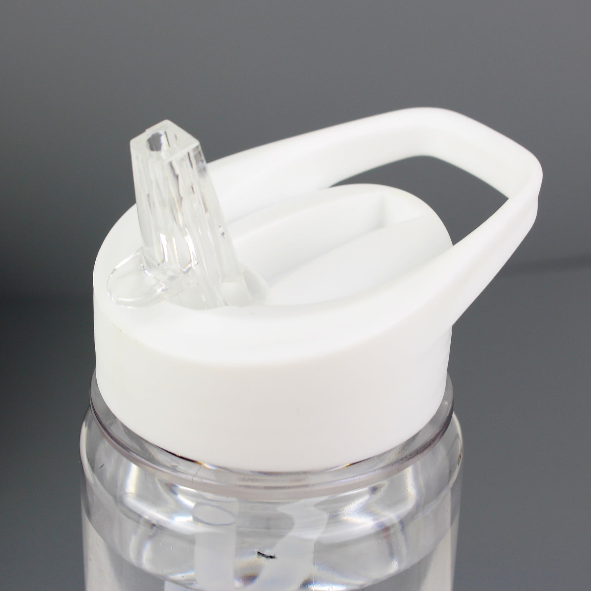Clear water bottle with a white cap on a grey background