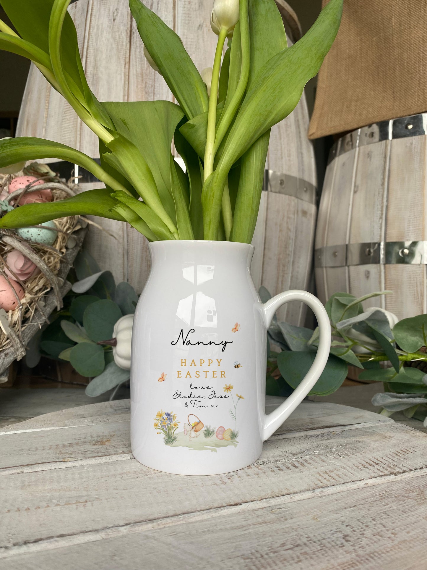 White ceramic jug with 'Happy Easter Nanny' message, featuring illustrated flowers, Easter eggs, butterflies, and personalised text