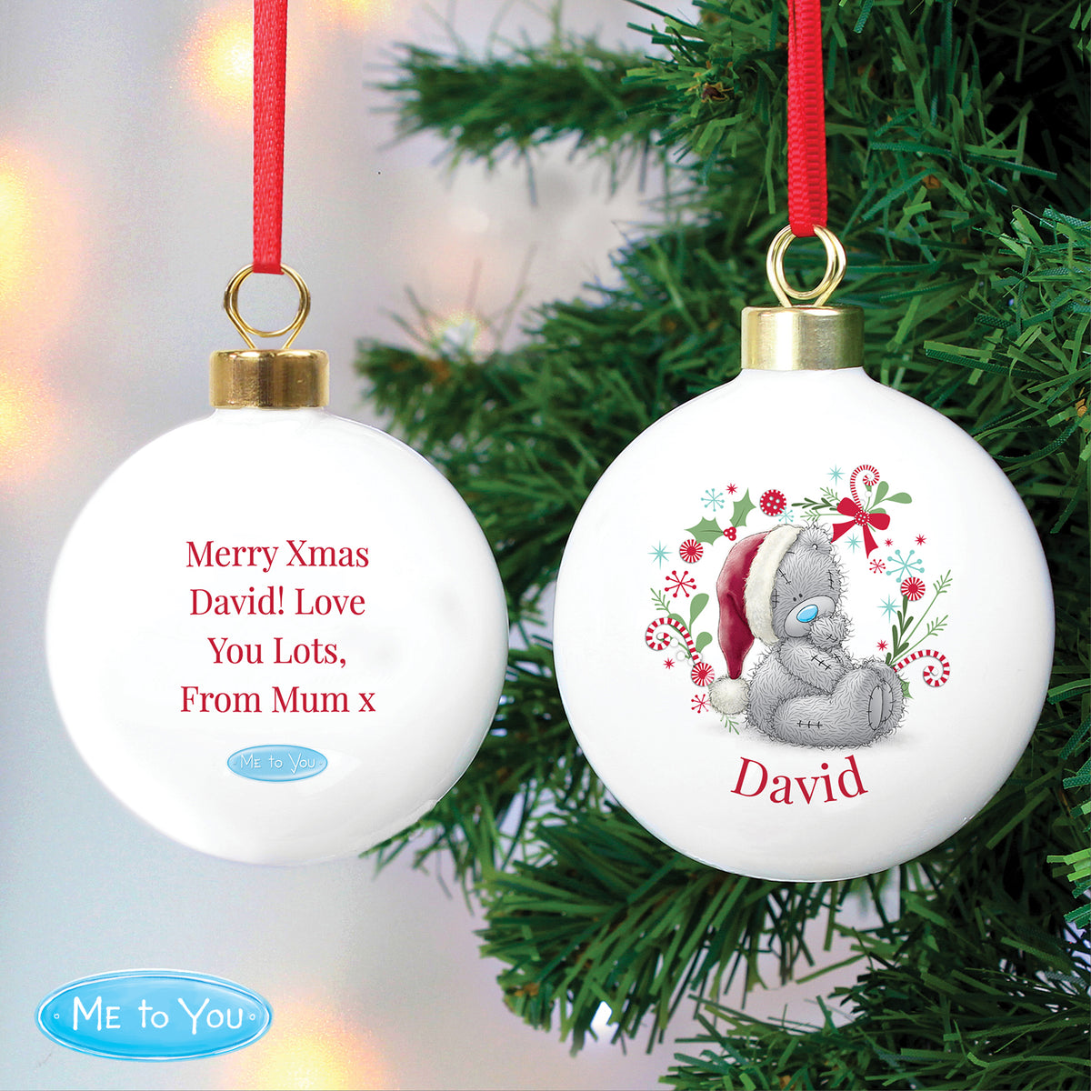 Two Christmas ornaments with personalised messages on a tree.
