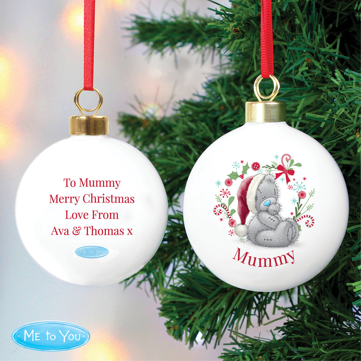 Two Christmas ornaments with personalised messages on a tree.