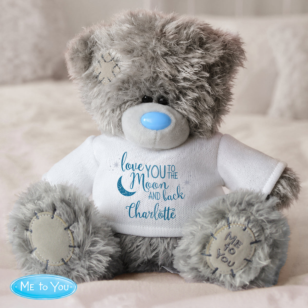 Grey teddy bear wearing a white shirt with text and 'Me to You' logo on a light background