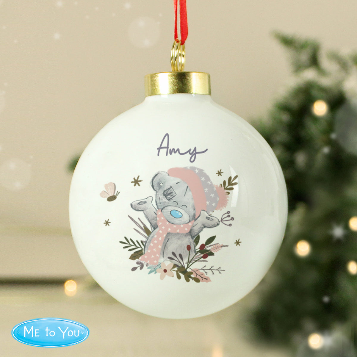 Decorative Christmas ball with a cartoon character and 'Elsie' text, hanging against a festive background.