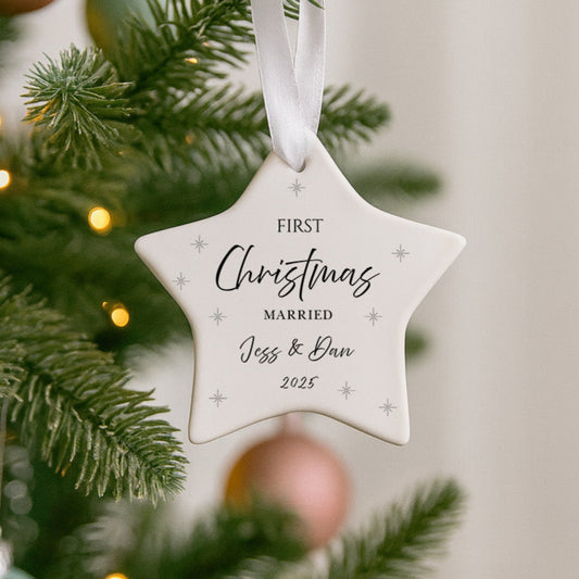 Star-shaped ornament on a Christmas tree with 'First Christmas Married Jess & Dan 2023' text.