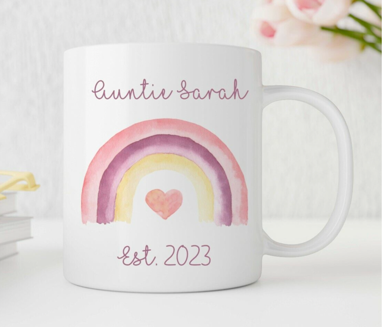 White mug with a rainbow and heart design, personalised with 'Auntie Sarah' and 'Est. 2023'.