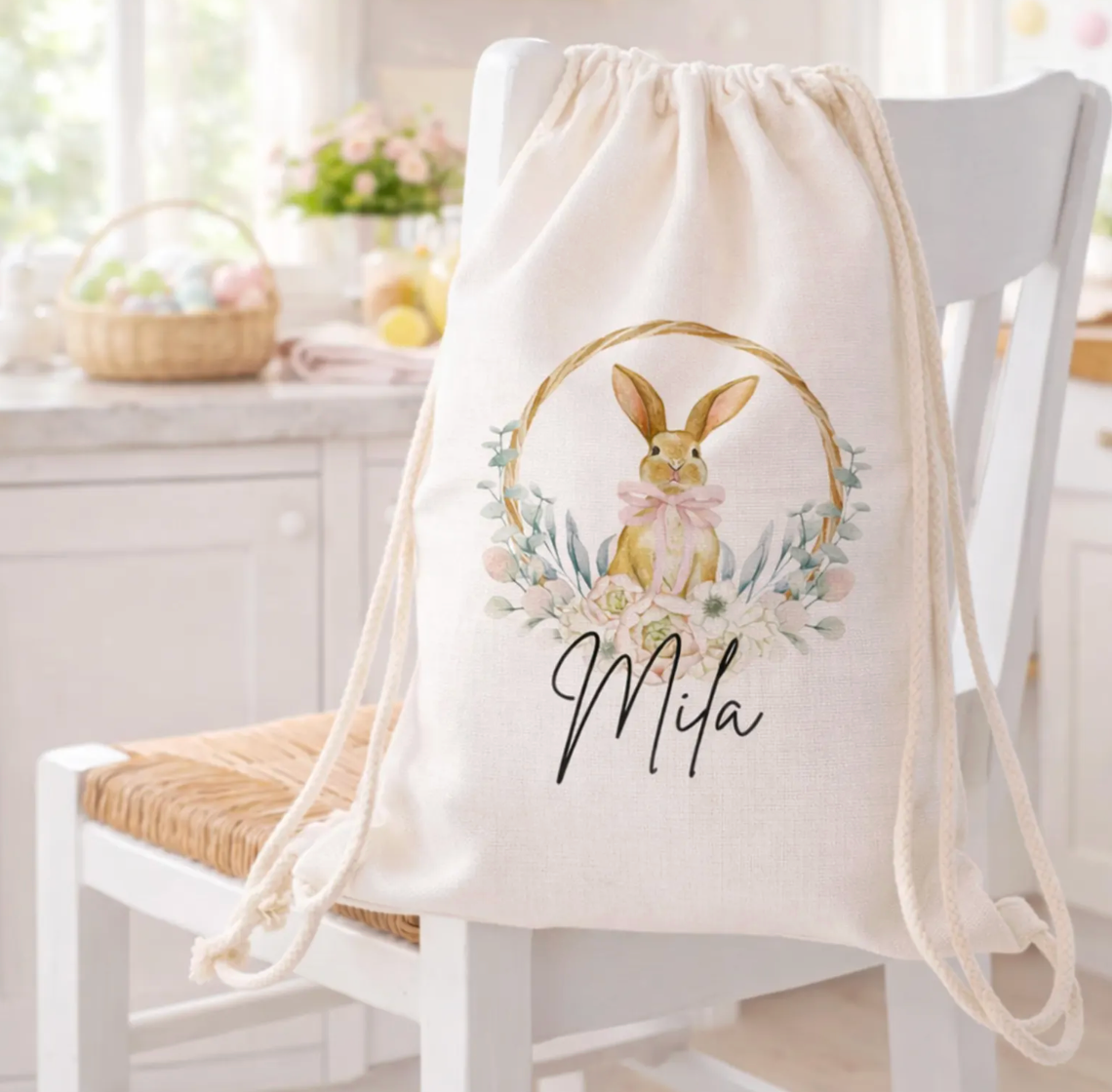 Drawstring bag with a bunny design and 'Mila' text on a chair in a bright room.
