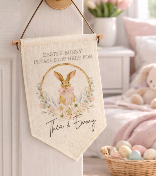 Decorative Easter banner with bunny and floral design, hanging on a wall.