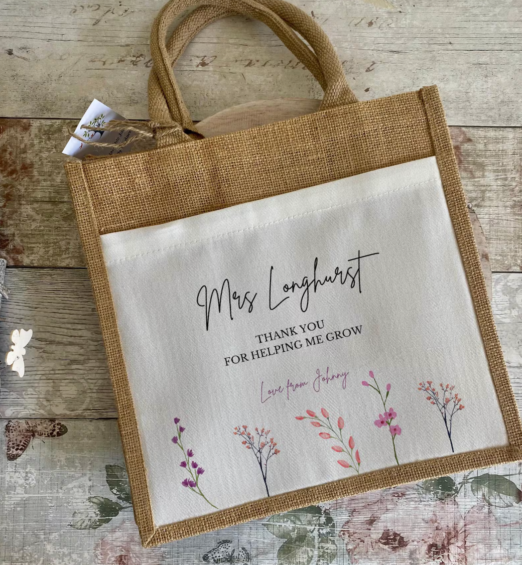 Personalised small Teacher Burlap tote bag with custom name 'Thank you for helping me grow' text and floral design on a wooden surface. 