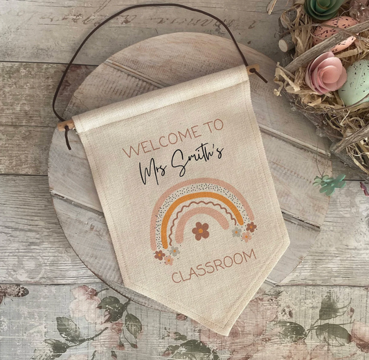 Personalised classroom banner with rainbow design on a wooden surface