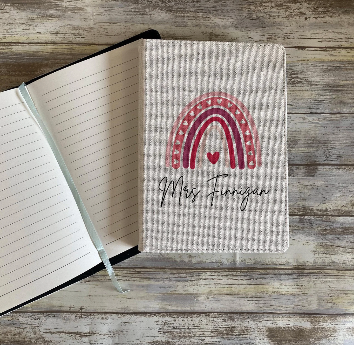 Notebook with a rainbow design and text on a wooden surface
