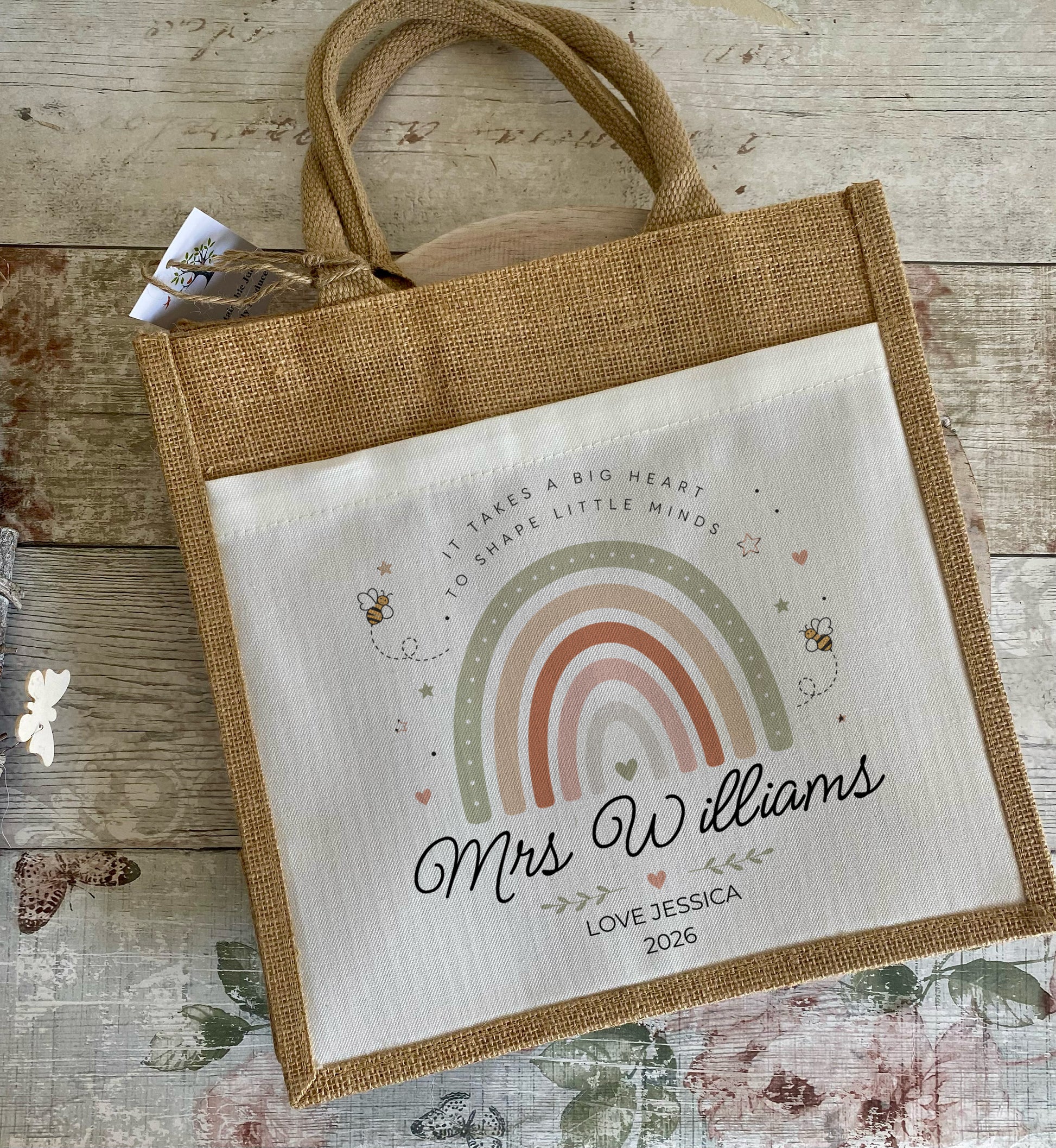 Personalised Teacher tote bag with rainbow and Bee design and text on a wooden surface