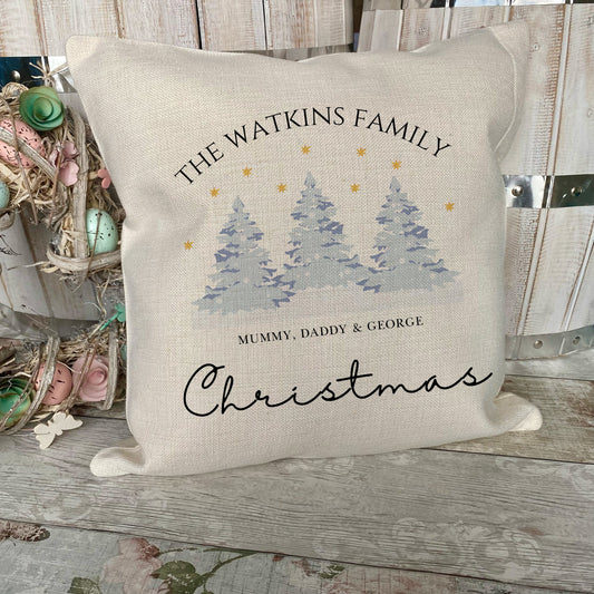 Decorative pillow with Christmas design and family name on a wooden surface
