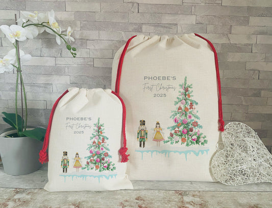 Two drawstring bags with Christmas-themed designs and text on a wooden surface.