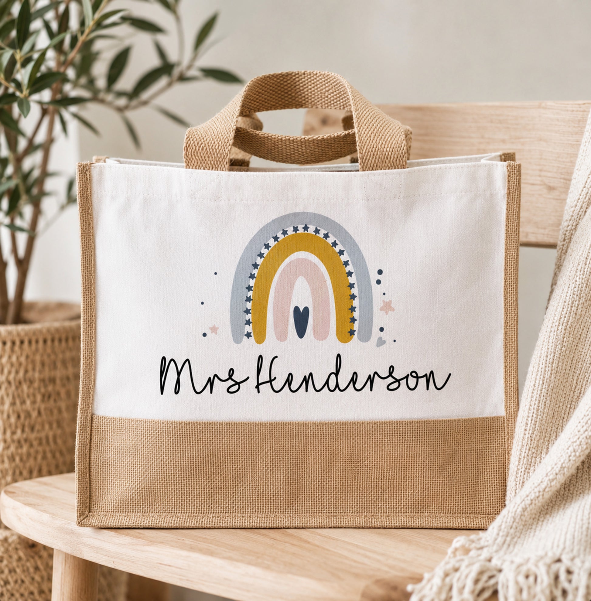 Canvas tote bag with rainbow design and 'Mrs Henderson' text on a wooden surface.