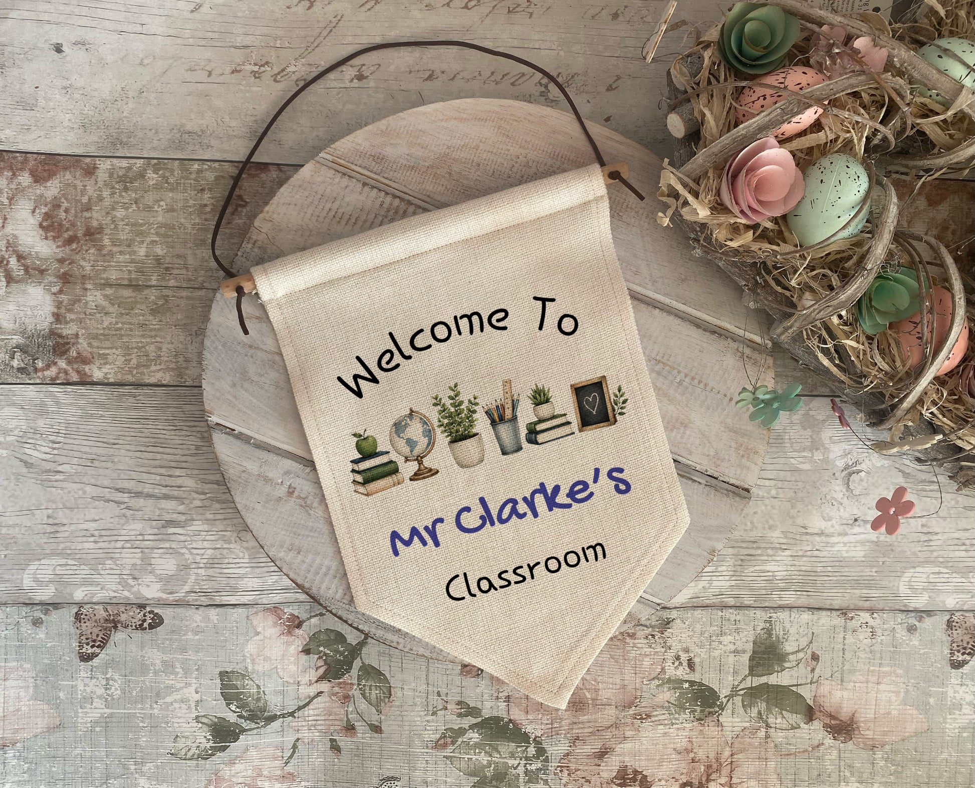 Decorative banner with 'Welcome to Mr Clarke's Classroom' text on a wooden surface with decorative elements.