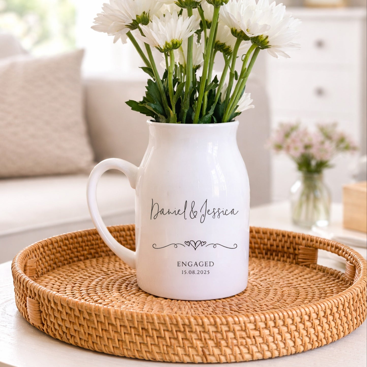 White personalised engagement vase with flowers on a woven tray in a living room setting