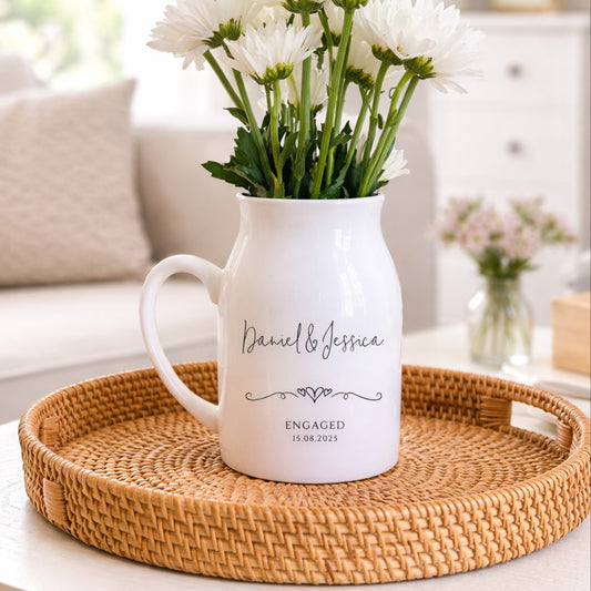 White personalised engagement vase with flowers on a woven tray in a living room setting