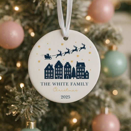Personalised Christmas ornament with family name and year on a decorated tree.