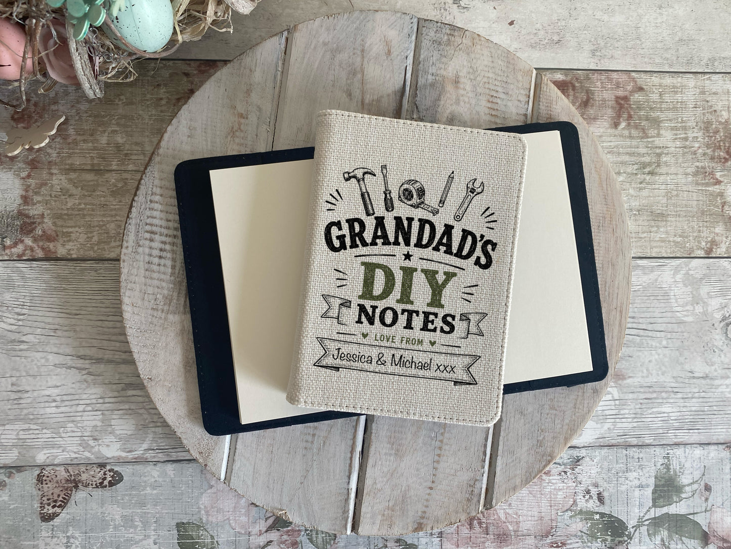 Notebook with 'Grandad's DIY Notes' cover on a wooden surface