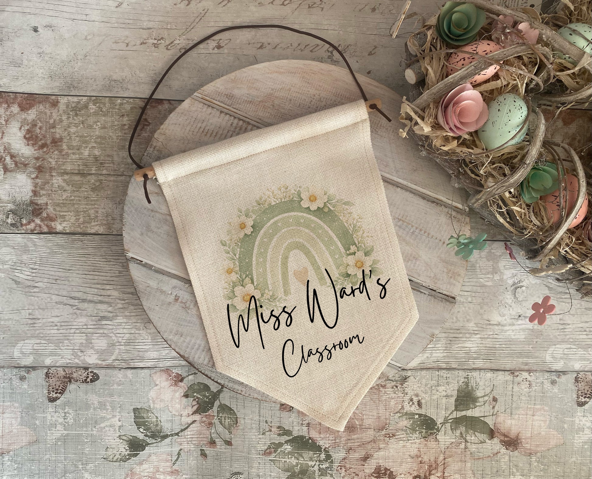 Decorative banner with rainbow and text on a wooden surface