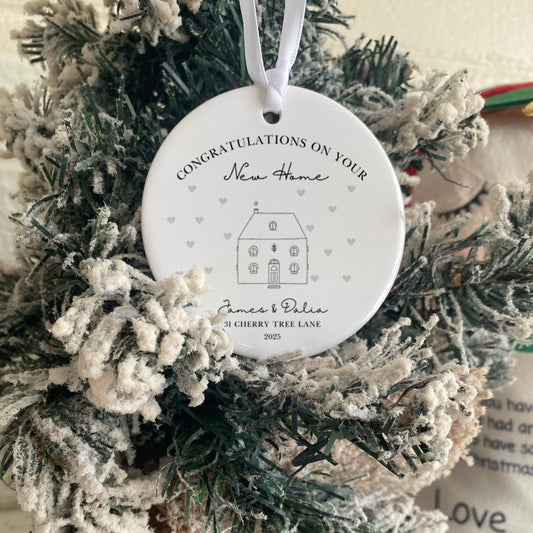 Decorative wreath with a 'Congratulations on Your New Home' ornament, featuring a house illustration.