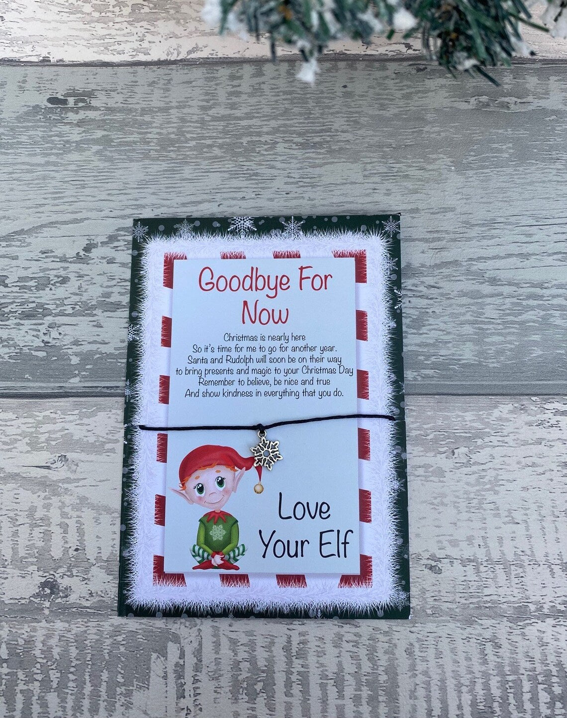 Card with text and elf illustration on a wooden surface