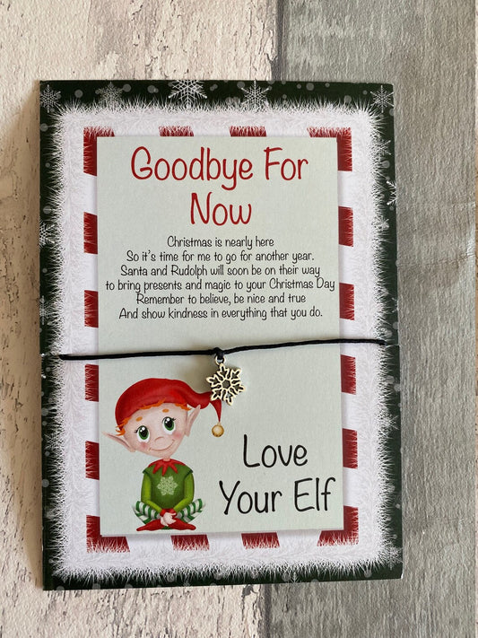 Goodbye for Now wish bracelet with text and an elf illustration on a wooden surface